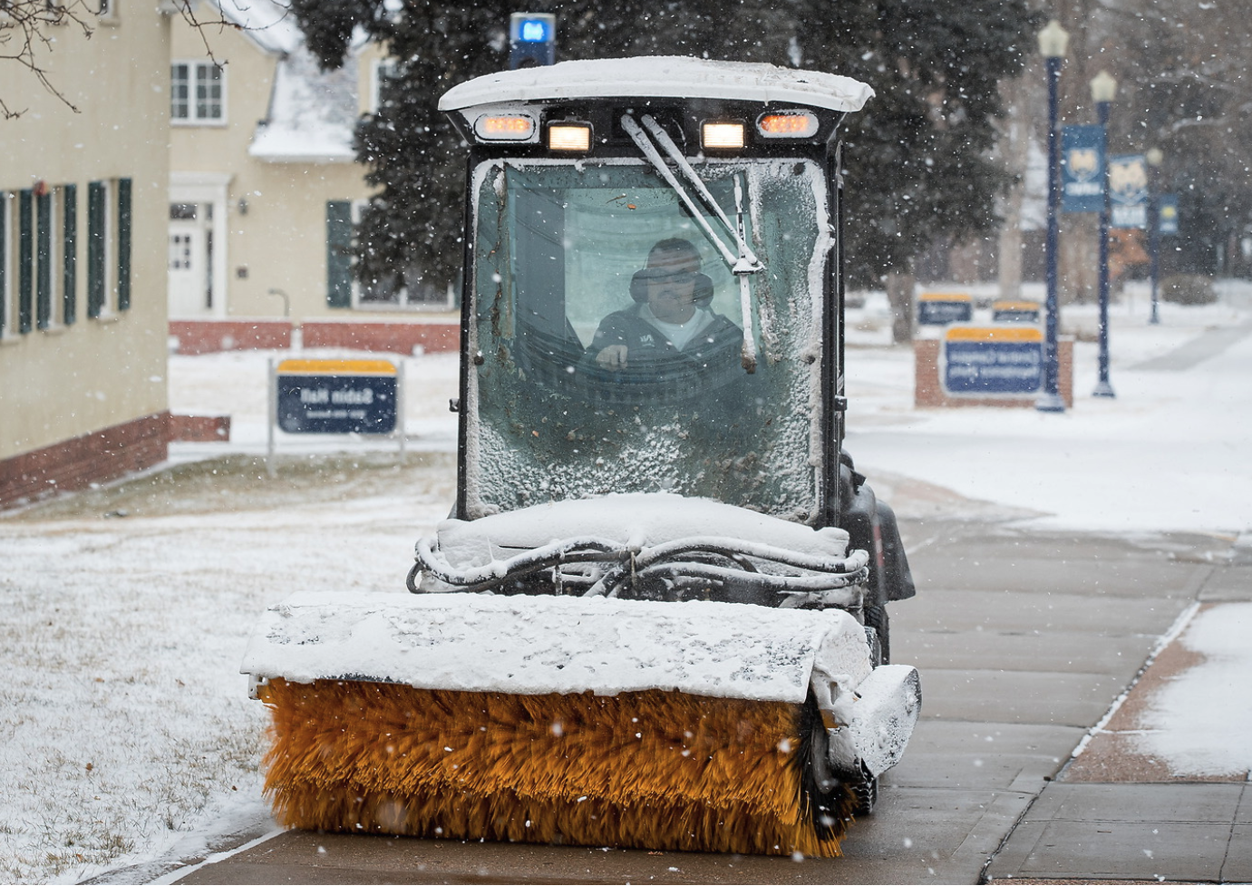 UNC设施成员清理人行道上的雪.